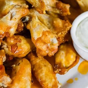 Keto Buffalo wings on a plate with dipping sauce.