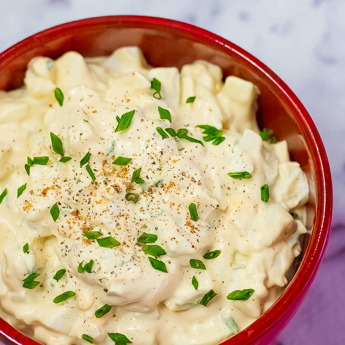 Keto egg salad in a red serving bowl.