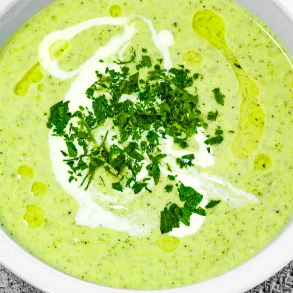 keto broccoli and leak soup granished with heavy cream and parsley.