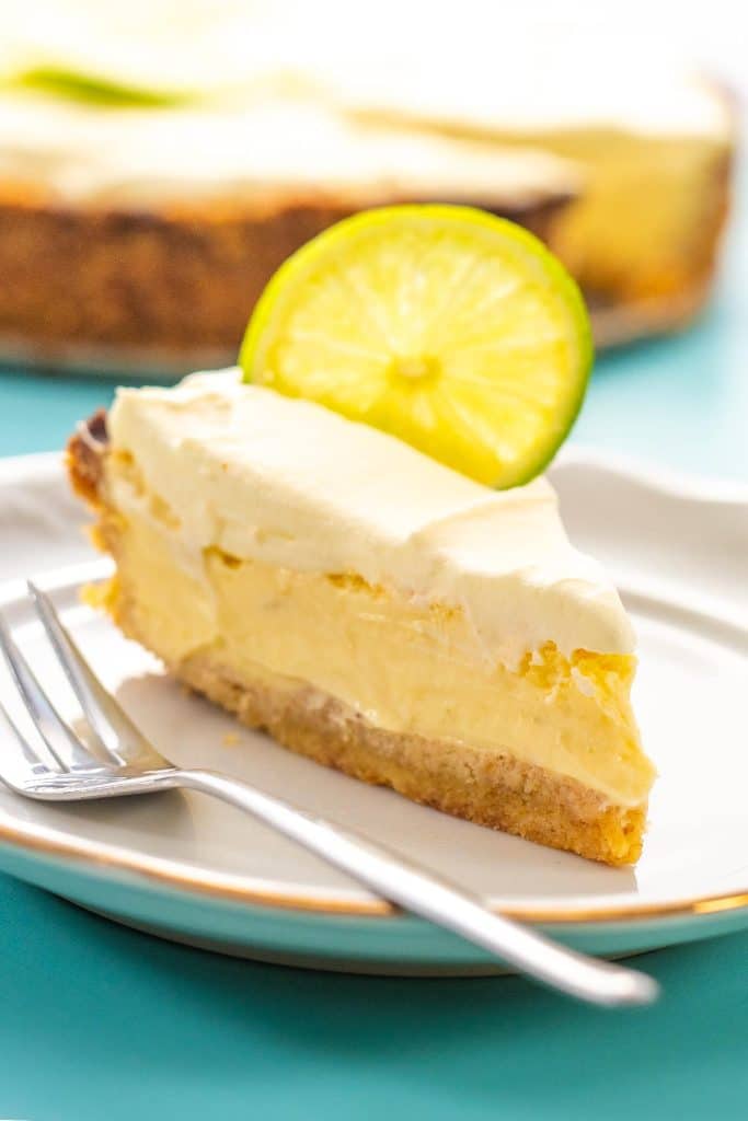 A slice of key lime pie on a white plate with a fork.