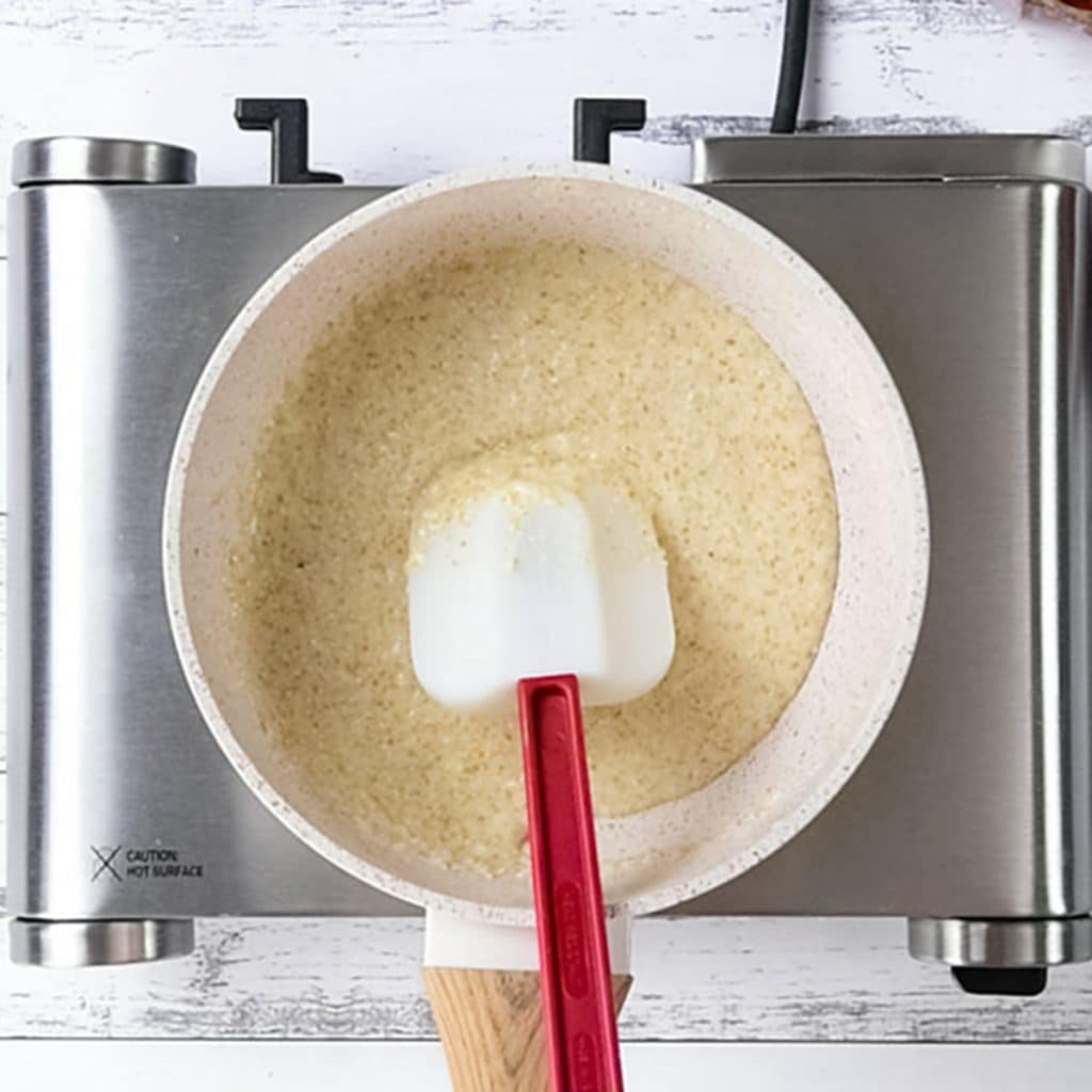 Keto porridge ingredients in a saucepan on a stove.