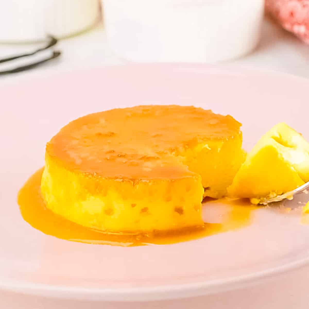 keto flan on a pink plate with a piece cut out.