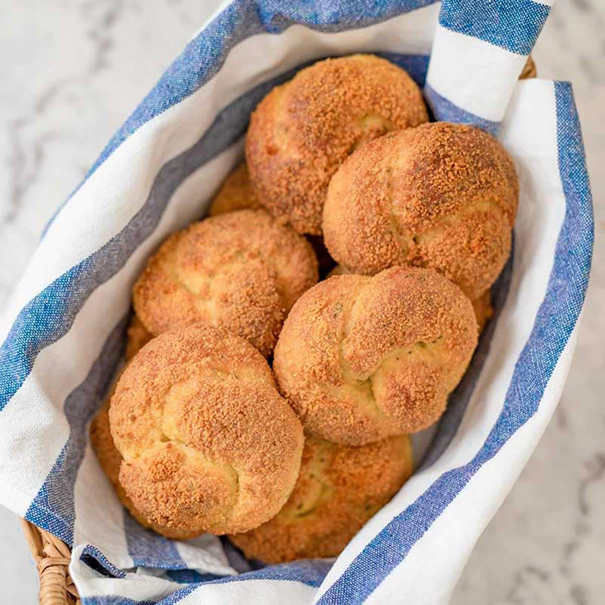 keto garlic bread in a basket with a blue and white tea towel.