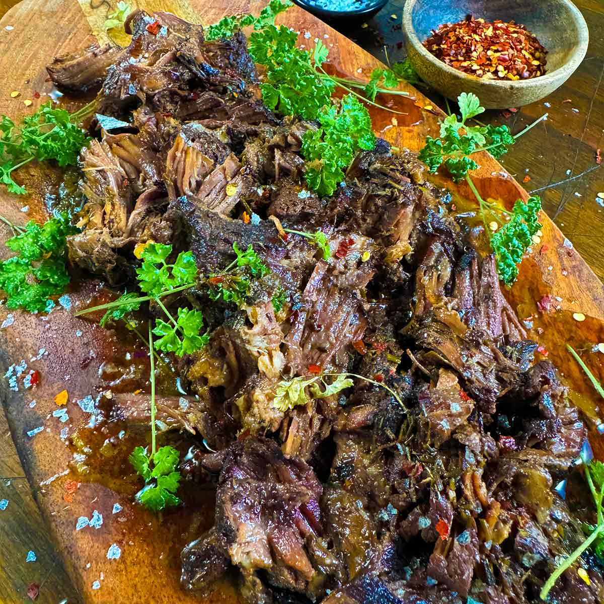 Carnivore slow cooked chuck roast on a wooden serving board.