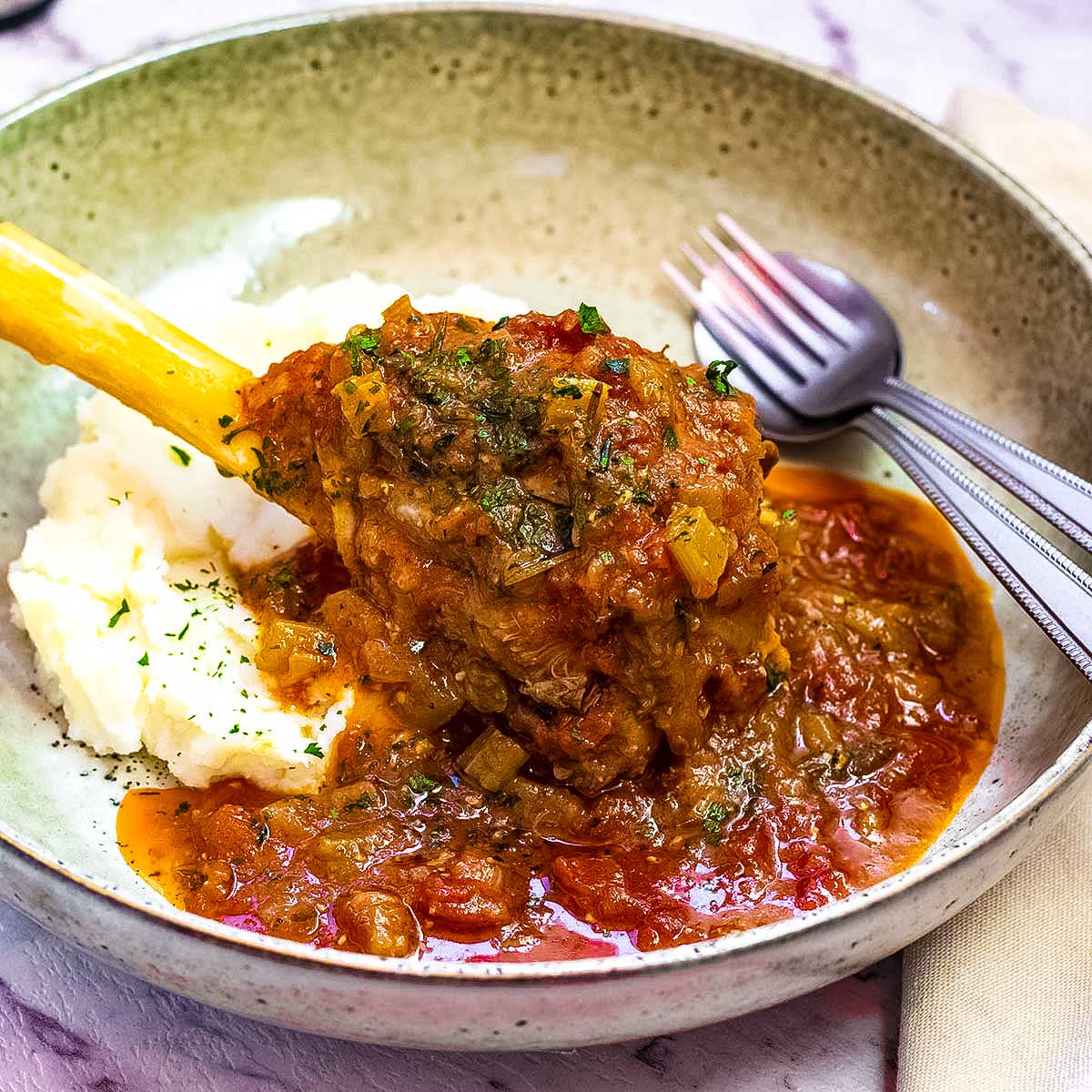 Keto slow cooker lamb shanks in a brown bowl.