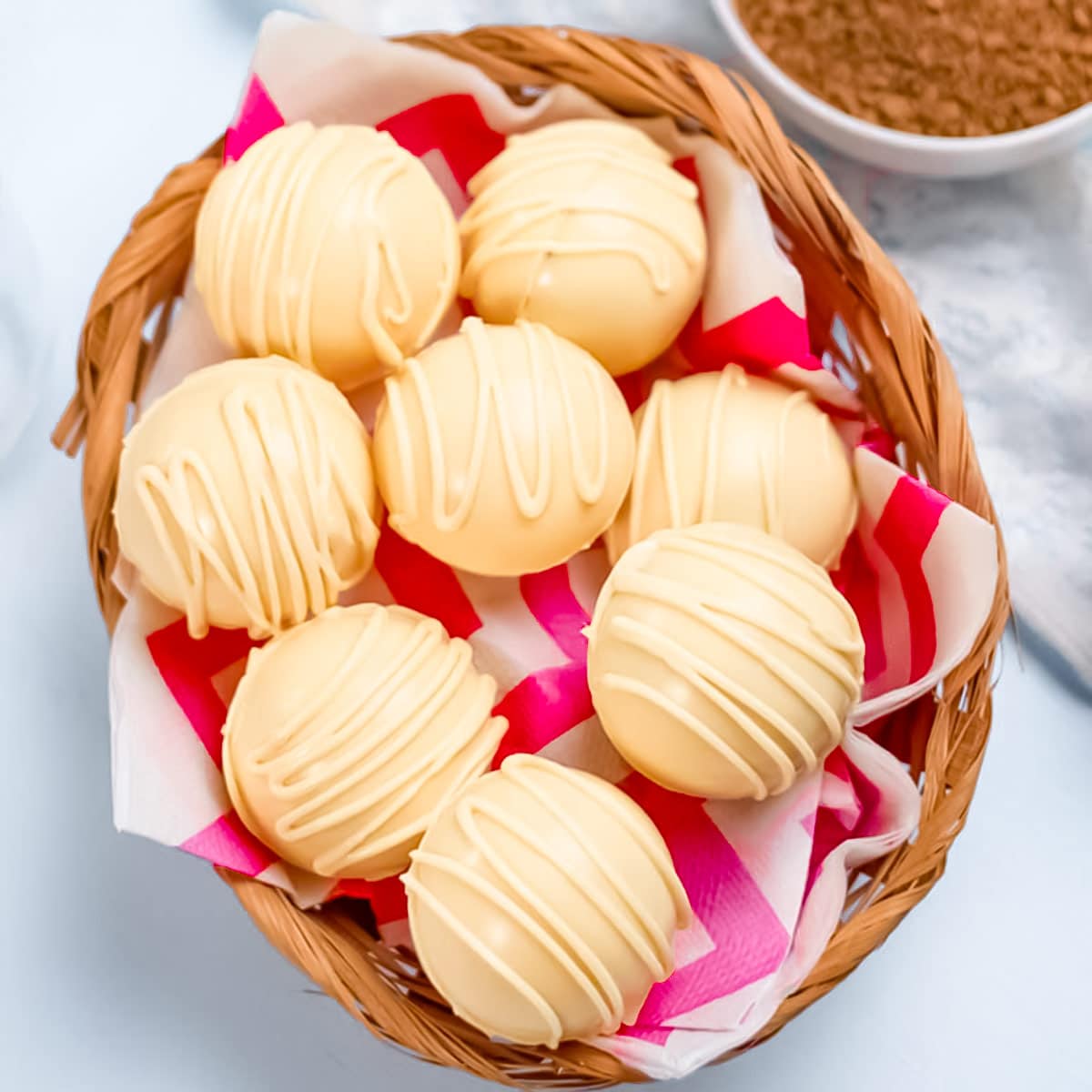 Eight keto fat bombs in a wicker basket with a red and white serviette.